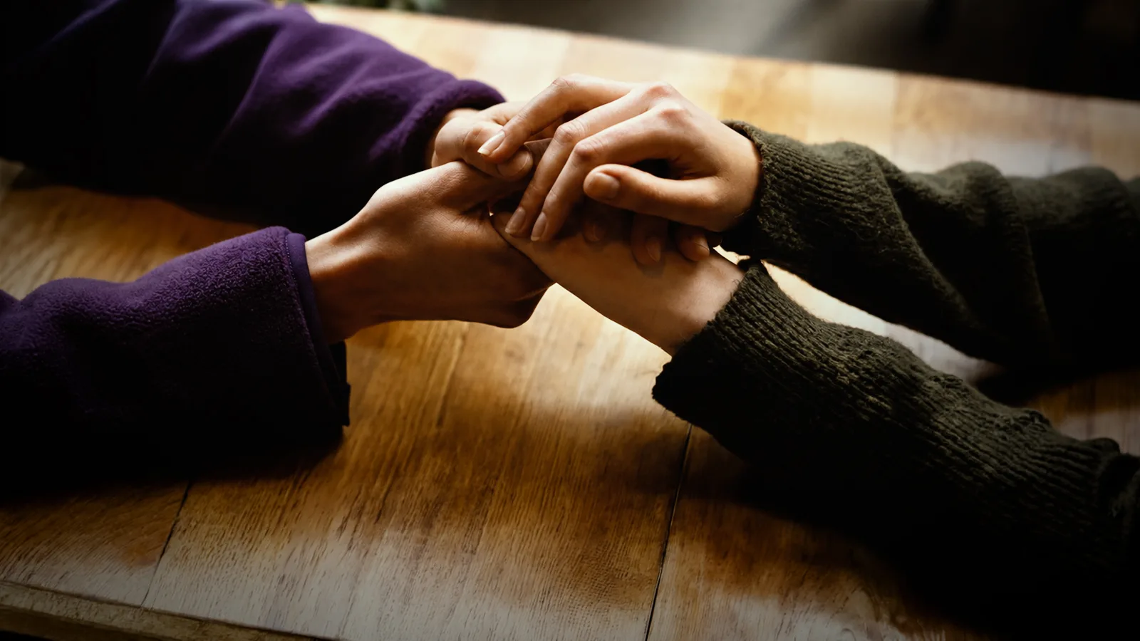 mãos unidas sobre uma mesa